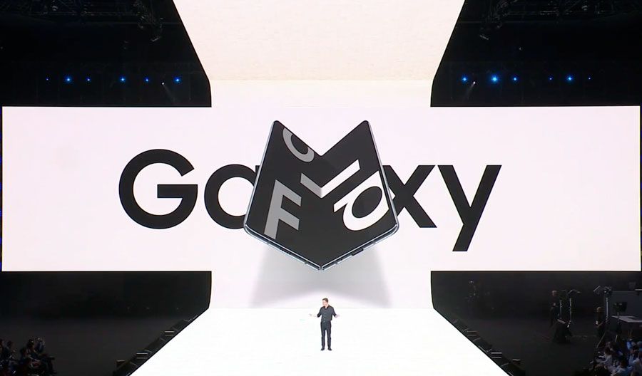 Escenario blanco donde se hizo la presentación del dispositivo. Se ve un hombre presentando y la imagen del Galaxy Fold a su espaldar.